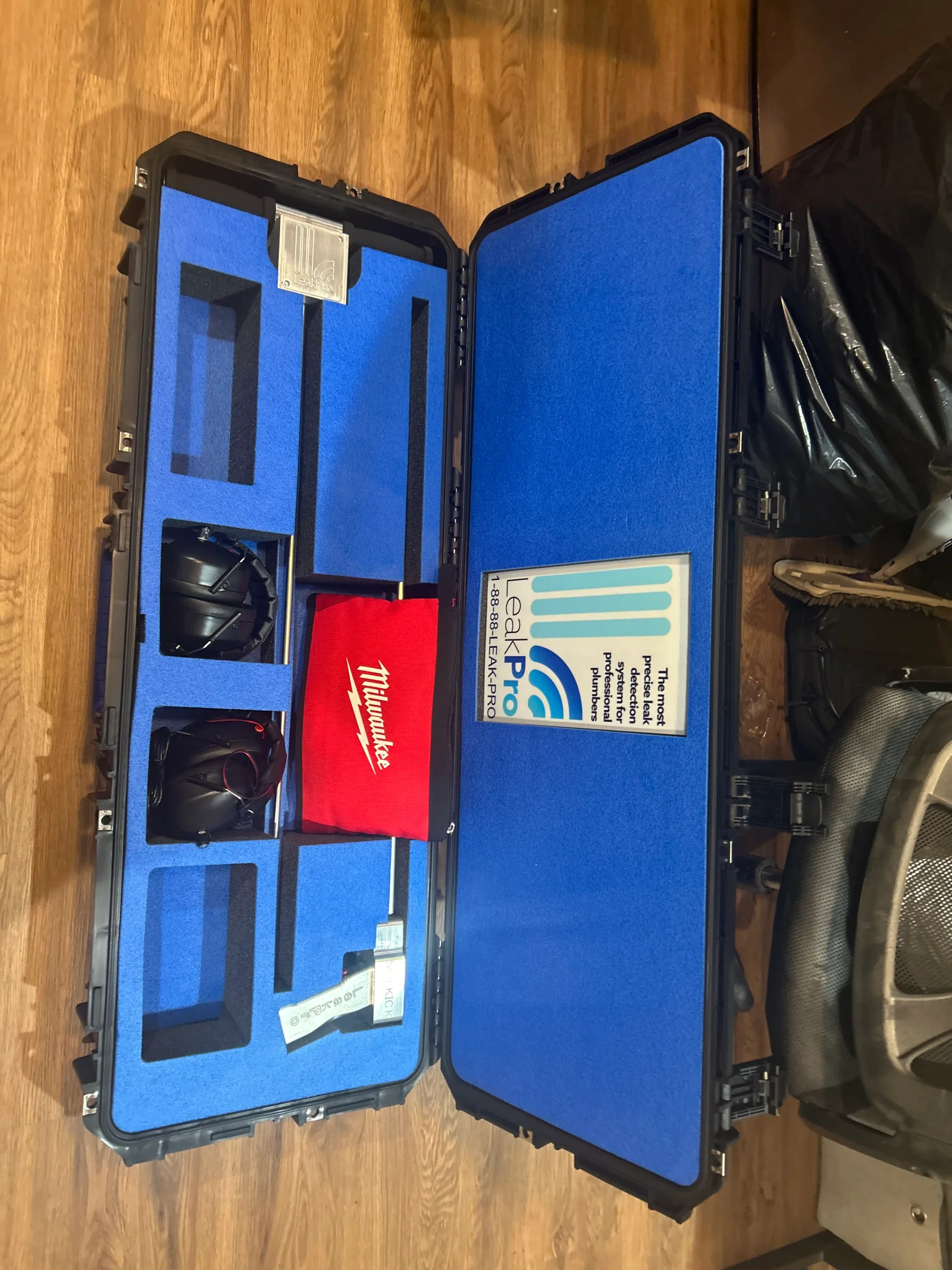 Open blue-lined case with LeakPro acoustic leak detection headphones, probe, and red Milwaukee tool bag